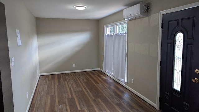 foyer with dark wood-style floors, baseboards, and a wall mounted air conditioner