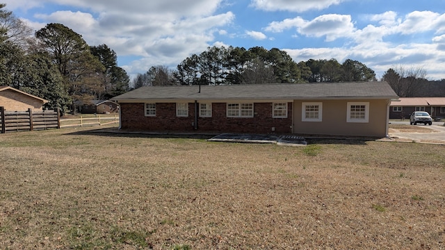 back of house with a yard, brick siding, and fence