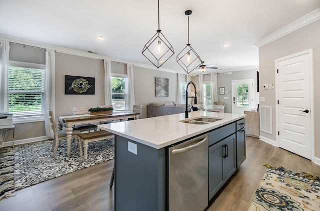 kitchen with a center island with sink, open floor plan, light countertops, stainless steel dishwasher, and a sink