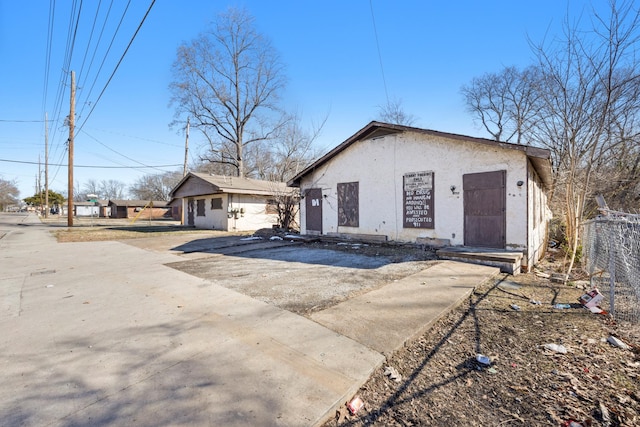 view of side of property featuring fence and stucco siding