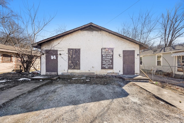 bungalow-style house featuring fence and stucco siding