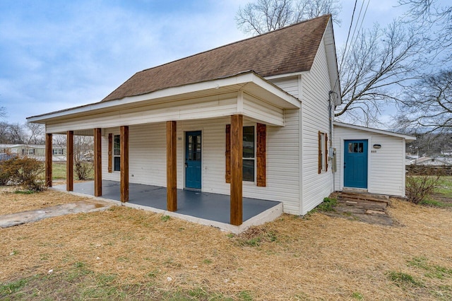 exterior space featuring entry steps, a shingled roof, and a porch