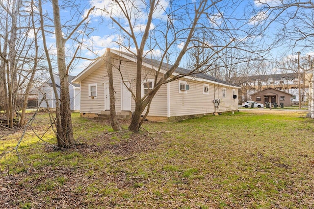 view of side of property with crawl space and a lawn