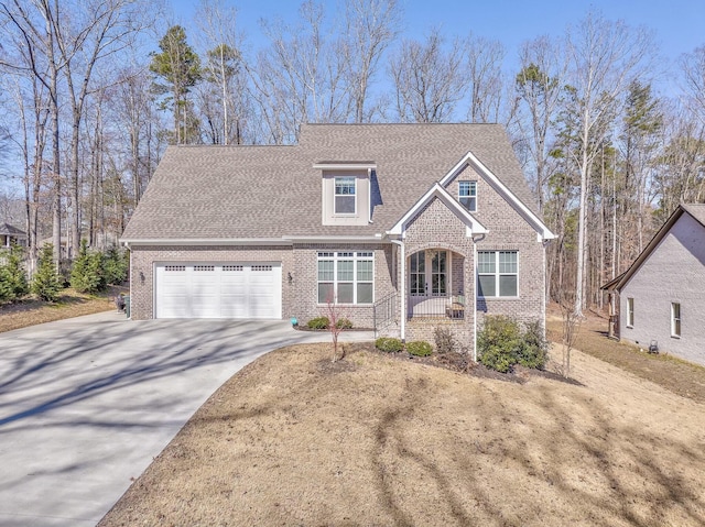 view of front facade with a garage, driveway, a shingled roof, and brick siding