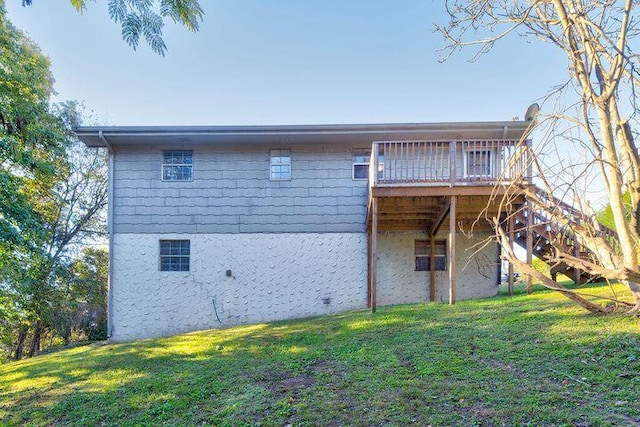 rear view of property featuring a yard and a deck