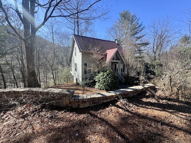 view of home's exterior featuring metal roof and a chimney