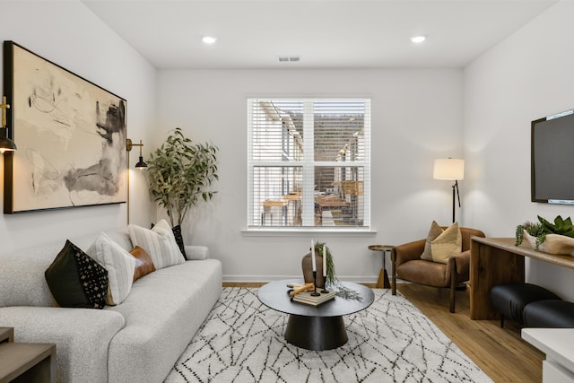 living room with visible vents, baseboards, light wood-style flooring, and recessed lighting