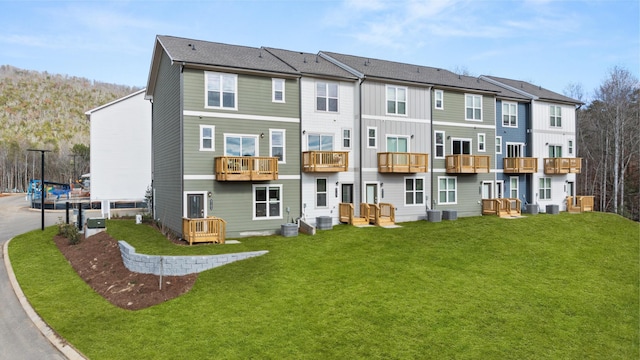 rear view of property with a lawn, a residential view, and central air condition unit