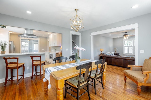 dining space with light wood-type flooring, a notable chandelier, and recessed lighting