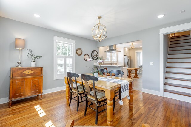 dining area featuring a chandelier, recessed lighting, baseboards, light wood-style floors, and stairway