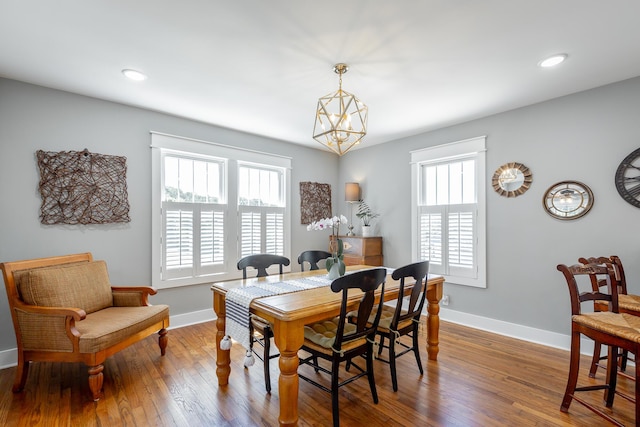 dining area featuring recessed lighting, a notable chandelier, baseboards, and wood finished floors