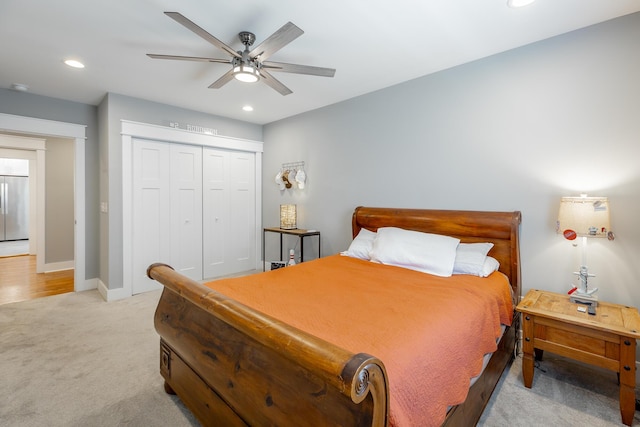 bedroom featuring stainless steel fridge, baseboards, light colored carpet, a closet, and recessed lighting
