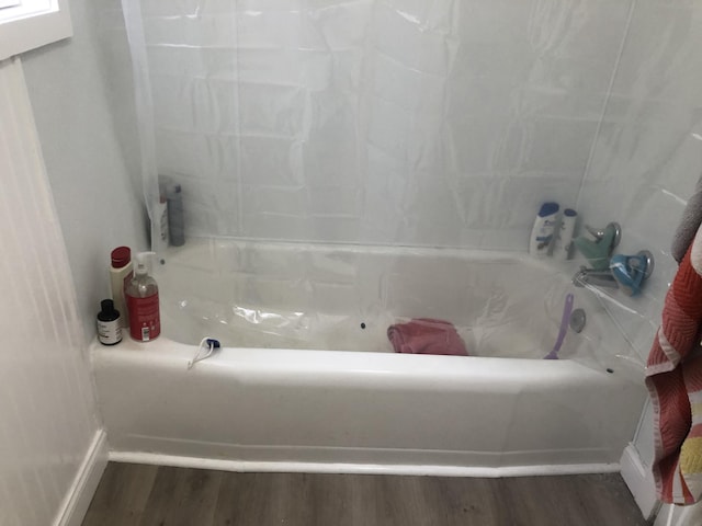 full bath with bathing tub / shower combination and wood finished floors