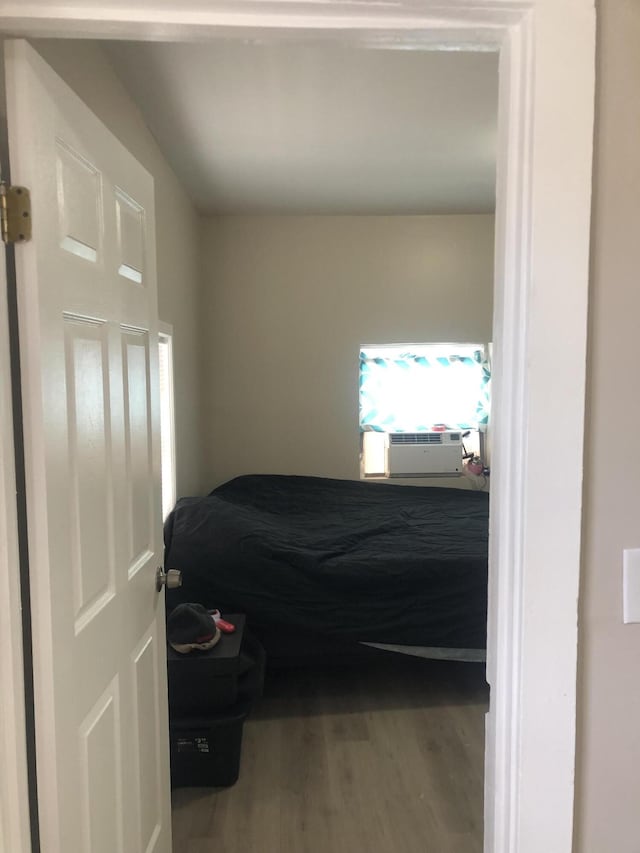 bedroom with cooling unit and wood finished floors