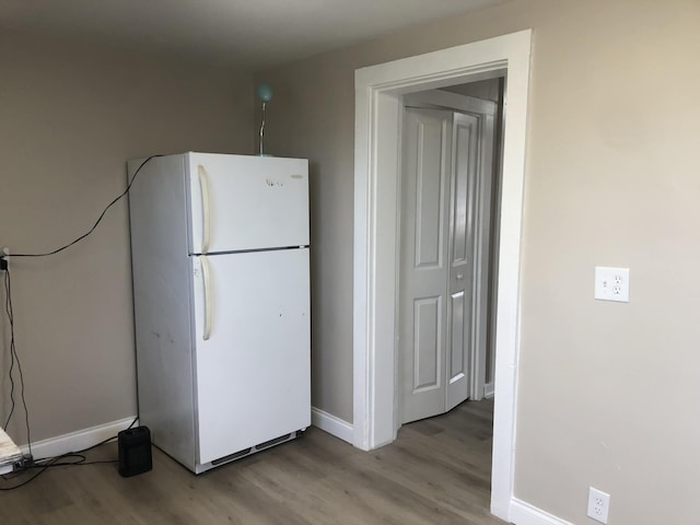 kitchen featuring freestanding refrigerator, baseboards, and wood finished floors