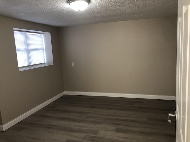 unfurnished room with dark wood-style floors, baseboards, and a textured ceiling