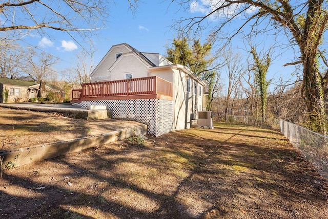 view of property exterior featuring a wooden deck and fence