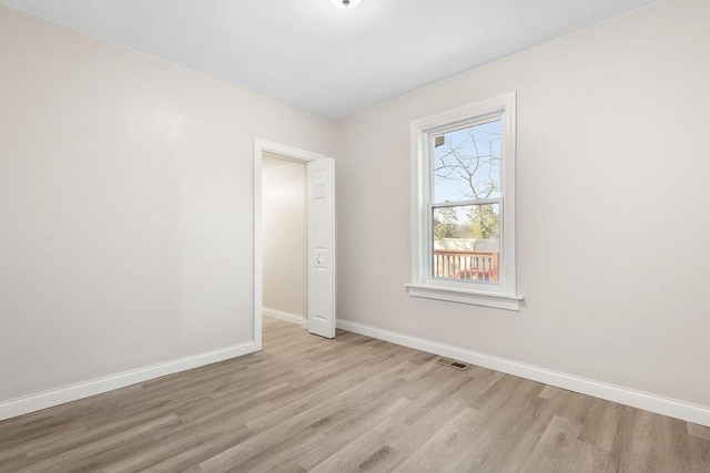 spare room featuring visible vents, light wood-type flooring, and baseboards