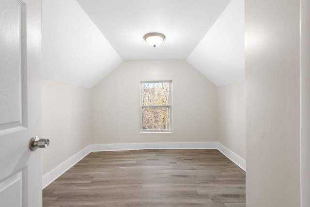 bonus room featuring baseboards, wood finished floors, and vaulted ceiling