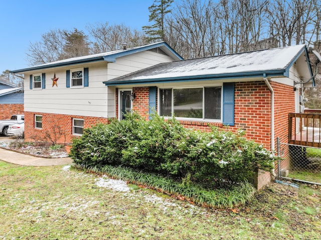 tri-level home featuring a front yard and brick siding