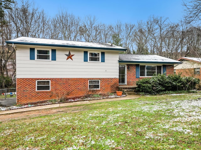 tri-level home with a front yard and brick siding