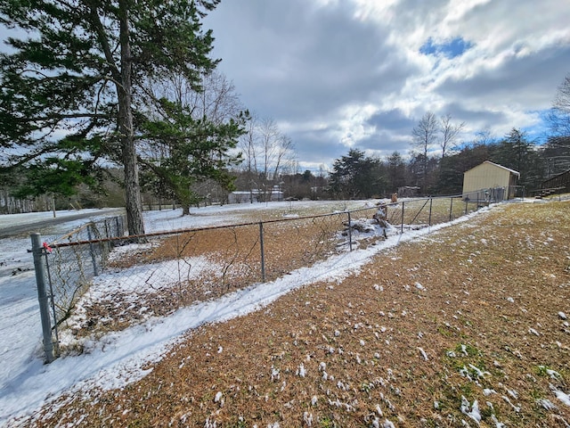 snowy yard featuring fence