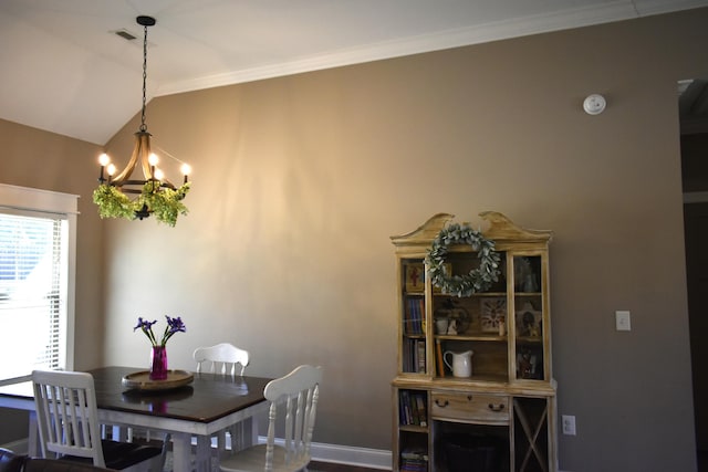 dining room featuring vaulted ceiling, crown molding, baseboards, and an inviting chandelier