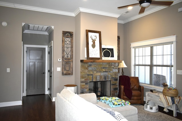 living area with baseboards, ceiling fan, ornamental molding, dark wood-type flooring, and a fireplace