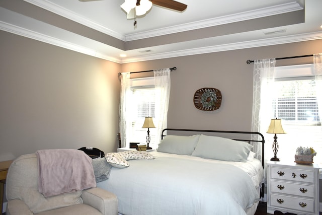 bedroom with ornamental molding, a tray ceiling, visible vents, and a wall unit AC