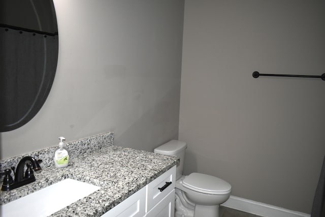 full bathroom featuring toilet, vanity, and baseboards