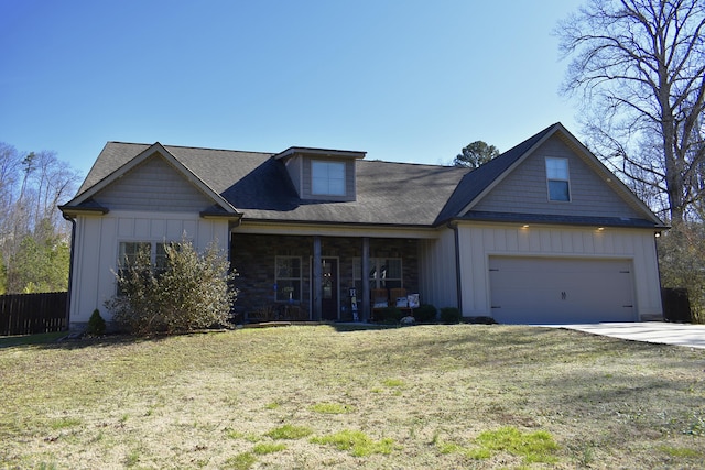 view of front of property featuring driveway, a garage, board and batten siding, and a front yard