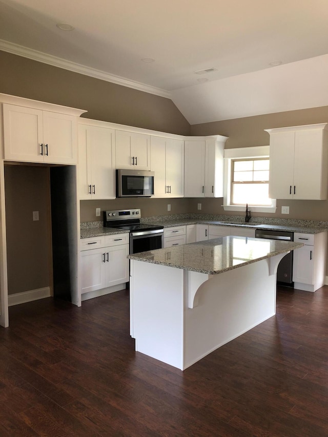 kitchen featuring stone counters, stainless steel appliances, dark wood-style flooring, a kitchen island, and white cabinets