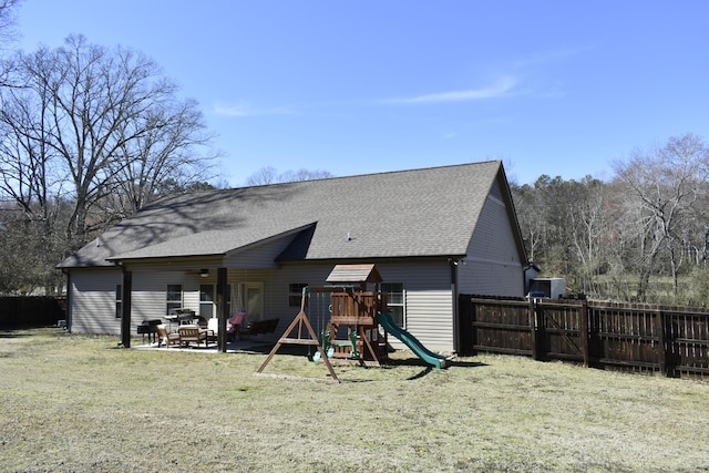 back of property with a patio, fence, a playground, and a yard