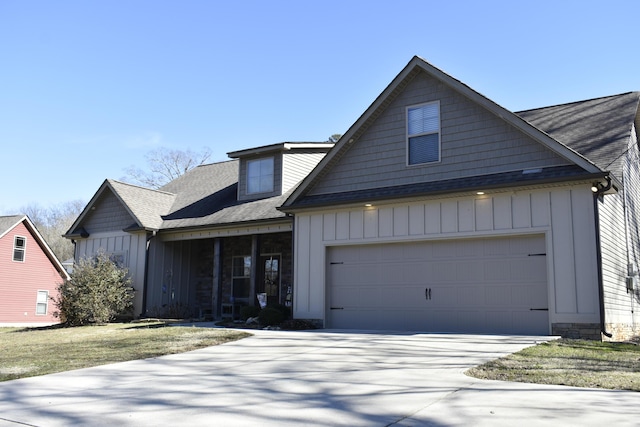 view of front of house with board and batten siding, concrete driveway, roof with shingles, and an attached garage