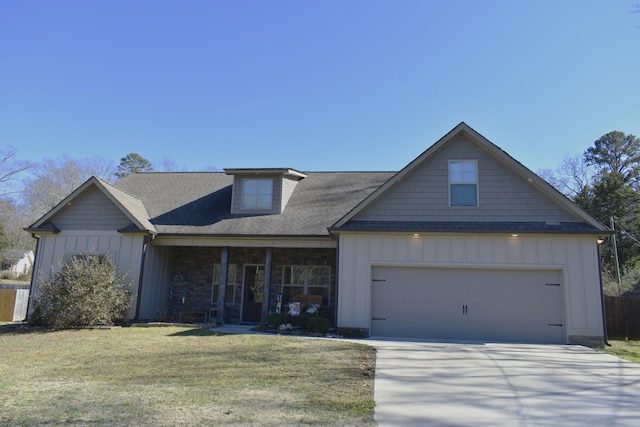 view of front of house with an attached garage, covered porch, concrete driveway, board and batten siding, and a front yard