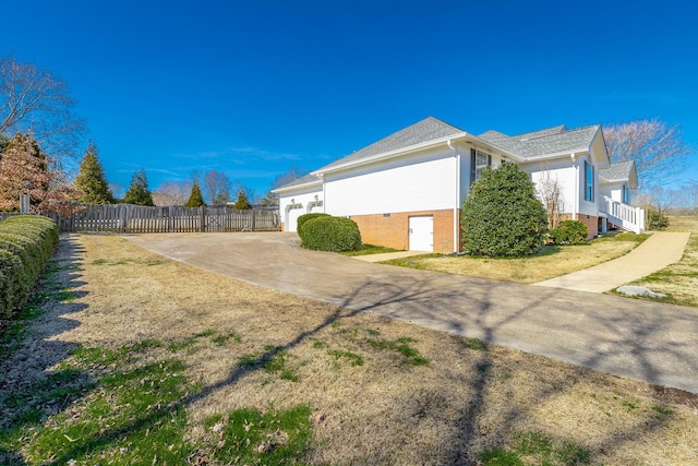 view of side of home with concrete driveway and fence