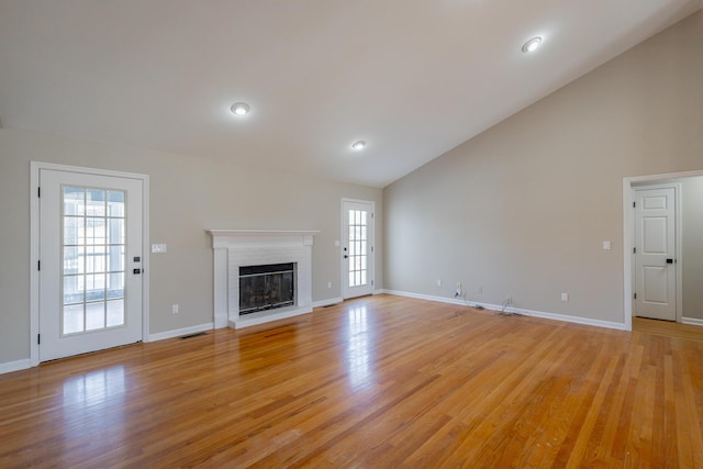 unfurnished living room featuring light wood-style flooring, a fireplace, visible vents, and baseboards