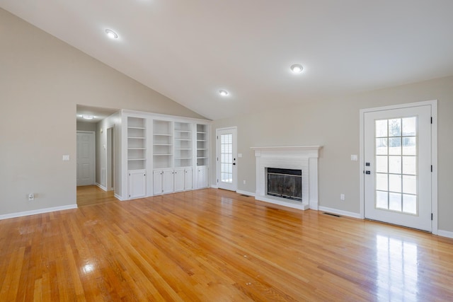 unfurnished living room with a brick fireplace, visible vents, light wood-style flooring, and baseboards