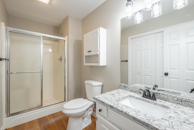 full bathroom featuring vanity, a stall shower, wood finished floors, and toilet