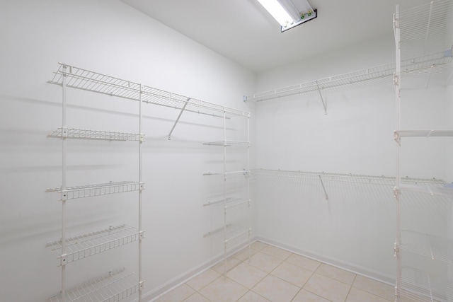 walk in closet with light tile patterned floors