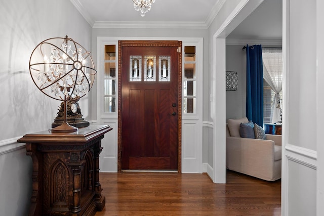 foyer entrance featuring a chandelier, crown molding, and wood finished floors