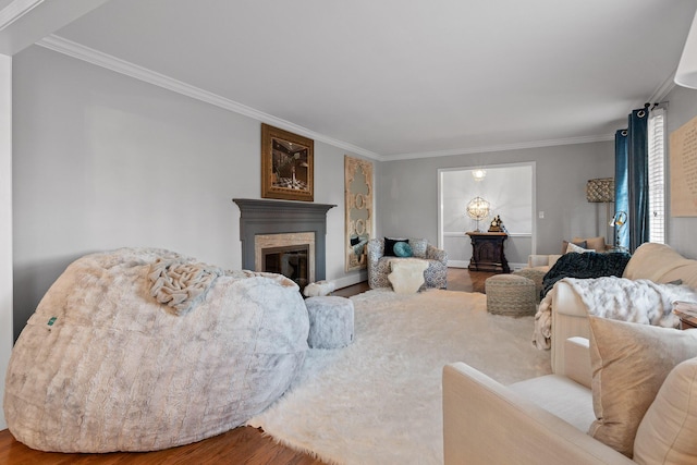 living room featuring ornamental molding, a glass covered fireplace, baseboards, and wood finished floors