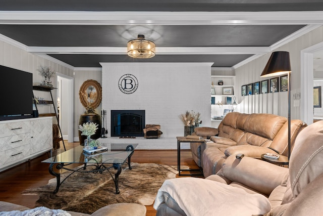 living area with a fireplace, wood finished floors, built in features, ornamental molding, and beamed ceiling