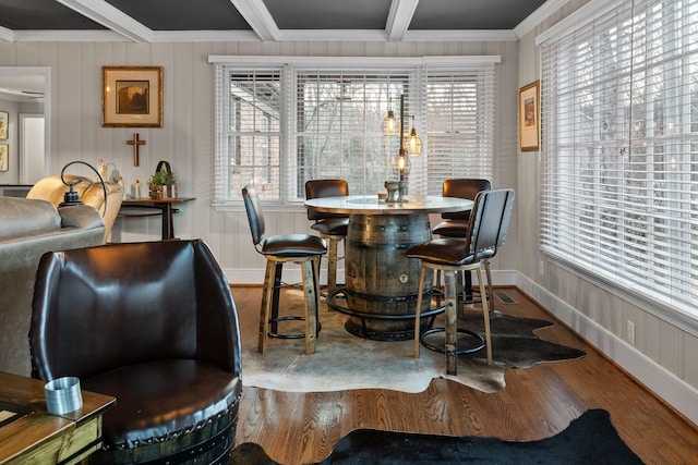 dining room with a wealth of natural light, beam ceiling, and wood finished floors