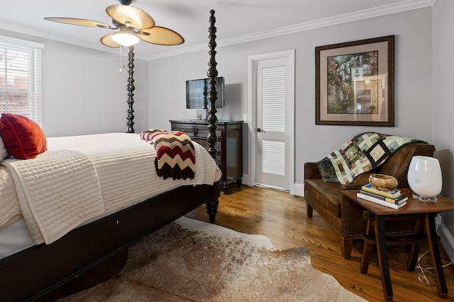 bedroom with baseboards, ceiling fan, wood finished floors, and crown molding