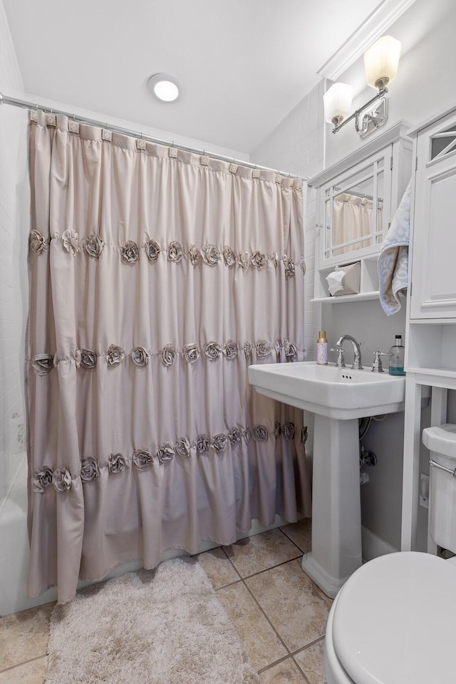 full bathroom with toilet and tile patterned floors