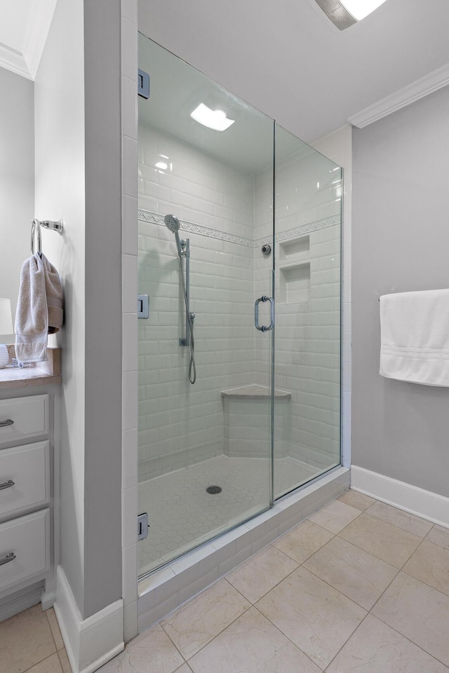 bathroom featuring vanity, baseboards, ornamental molding, a shower stall, and tile patterned floors