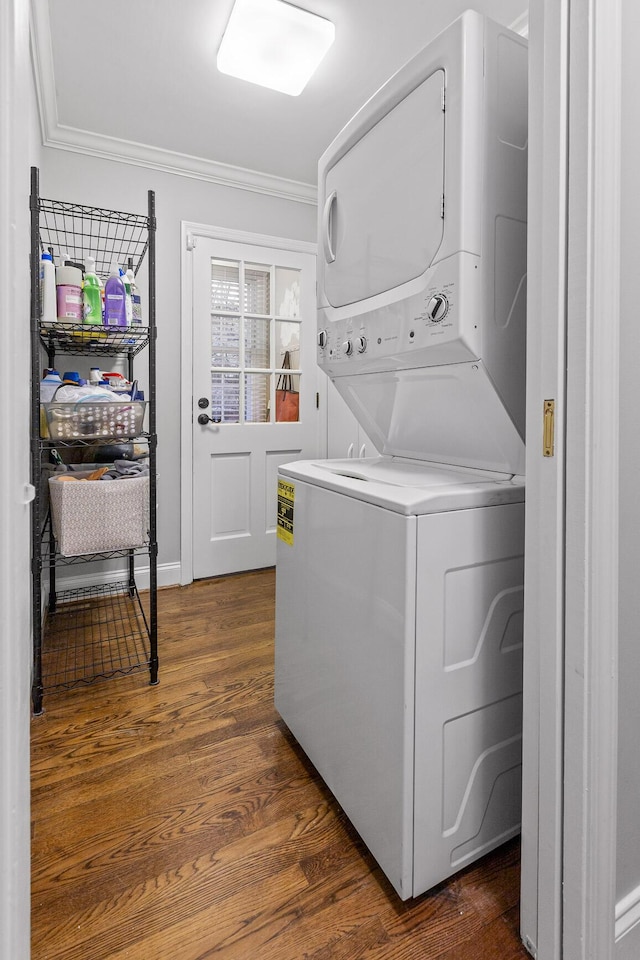 washroom with laundry area, baseboards, stacked washer and clothes dryer, dark wood-style floors, and ornamental molding