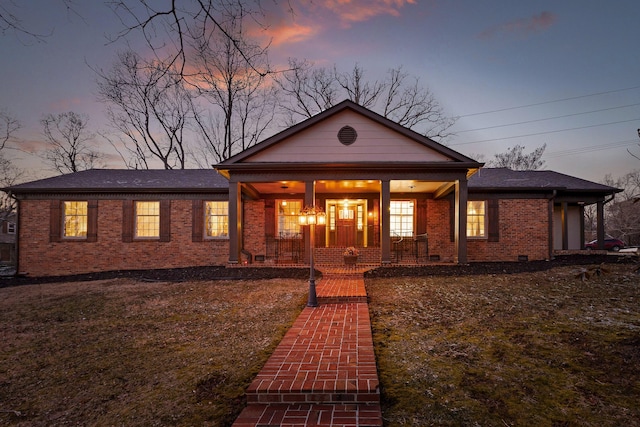 view of front facade featuring crawl space, covered porch, and brick siding