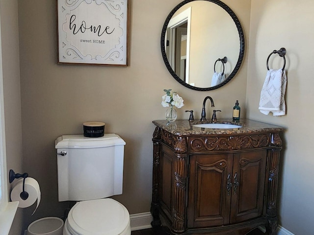 bathroom with toilet, baseboards, and vanity